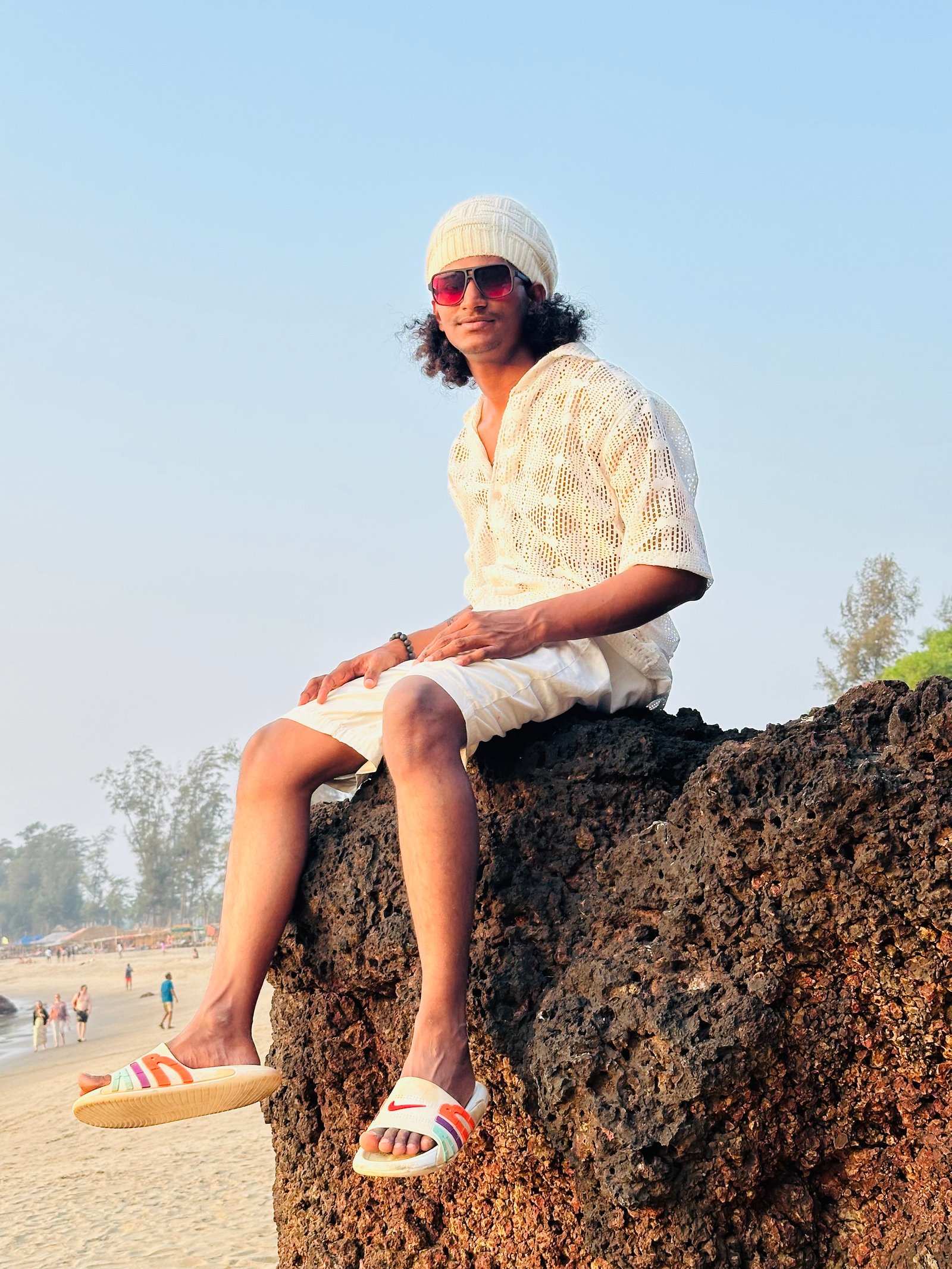 Omi sitting on rocks by the beach